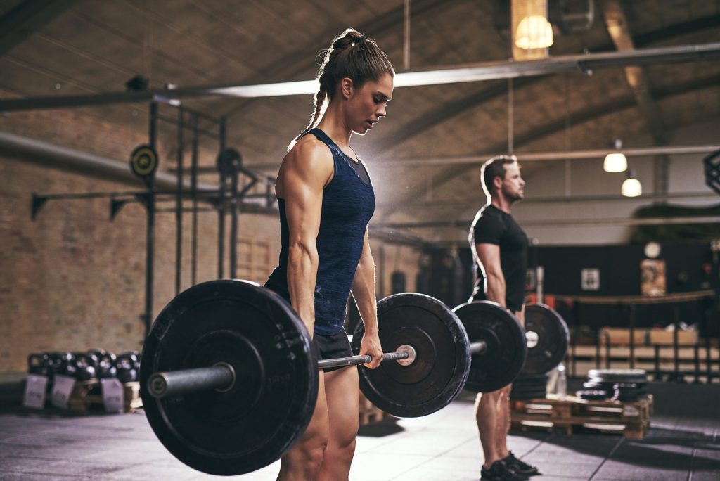 Athlete lifting a barbell during strength training to improve sports performance.