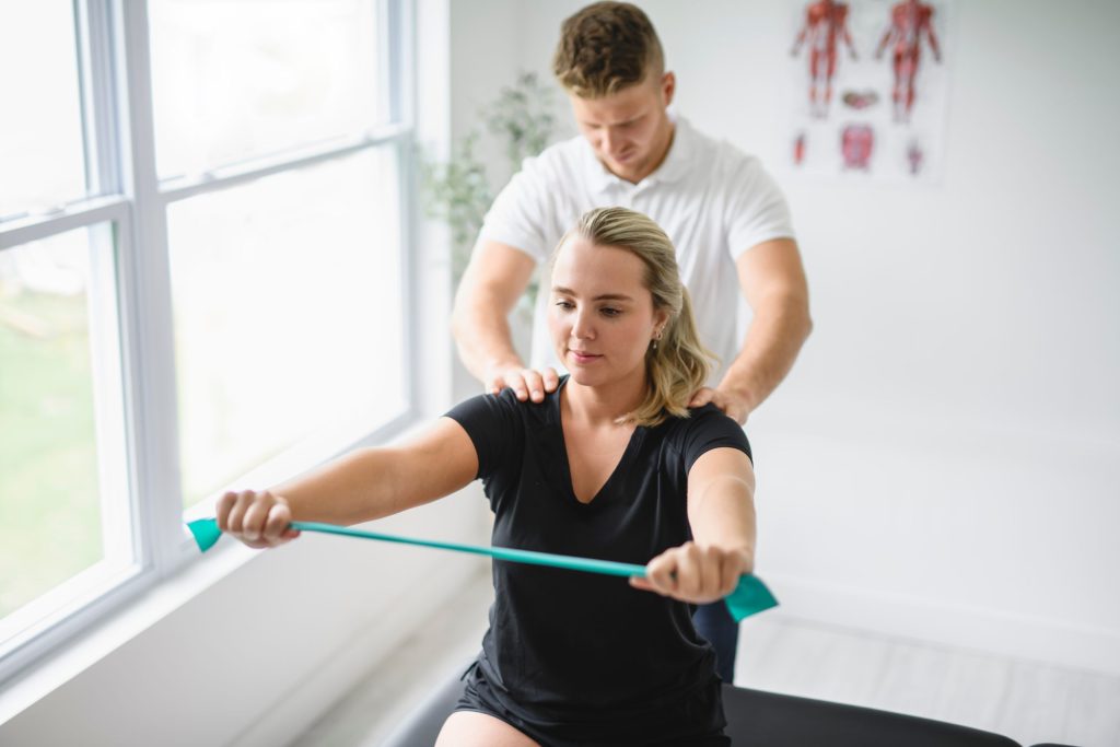 Patient performing guided strengthening exercise with physiotherapist supervision.