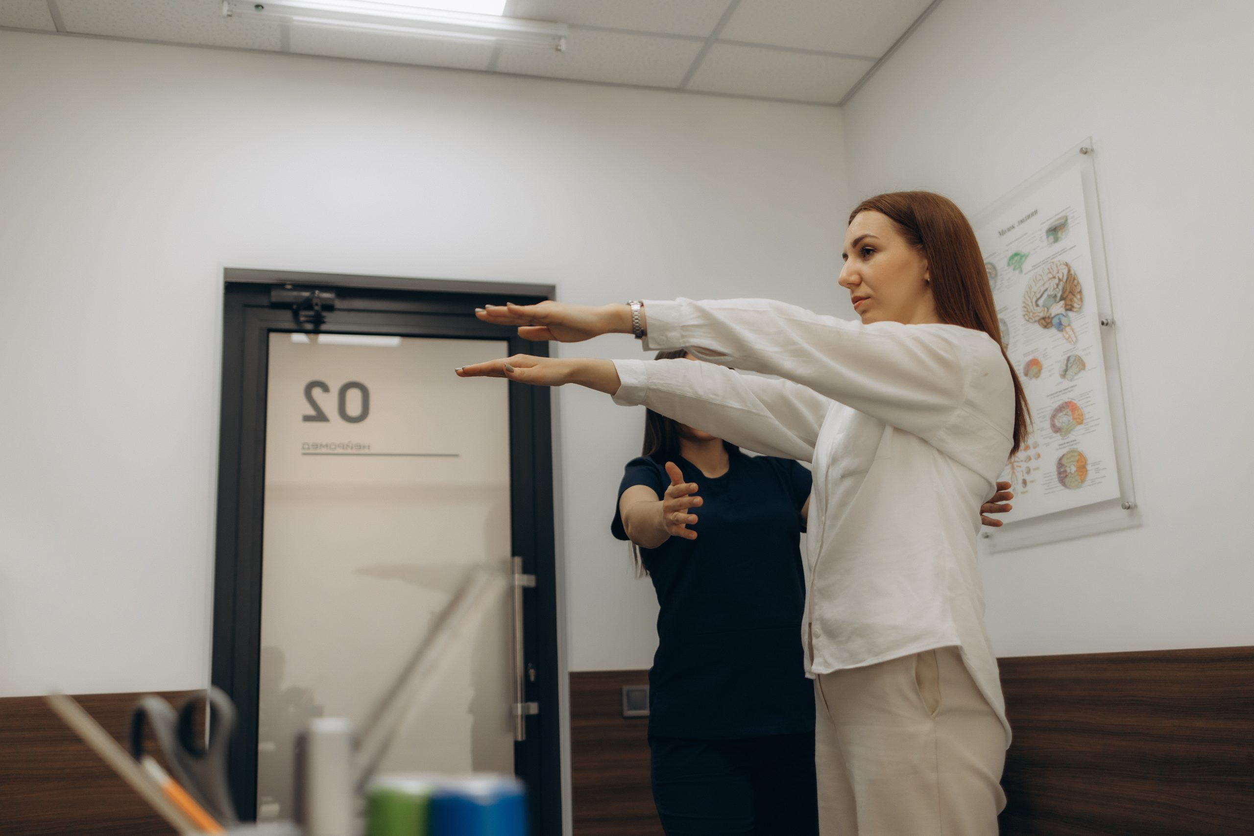 Therapist guiding a patient through a posture and balance assessment in clinic.