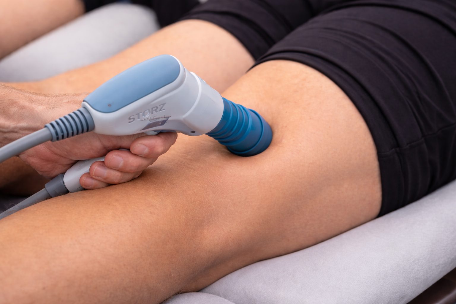 shockwave gun being placed against the back of the patients knee