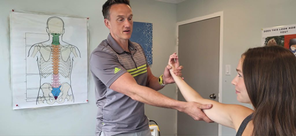 Dr. Steve Knighton showing a female patient why her arm pain is happening