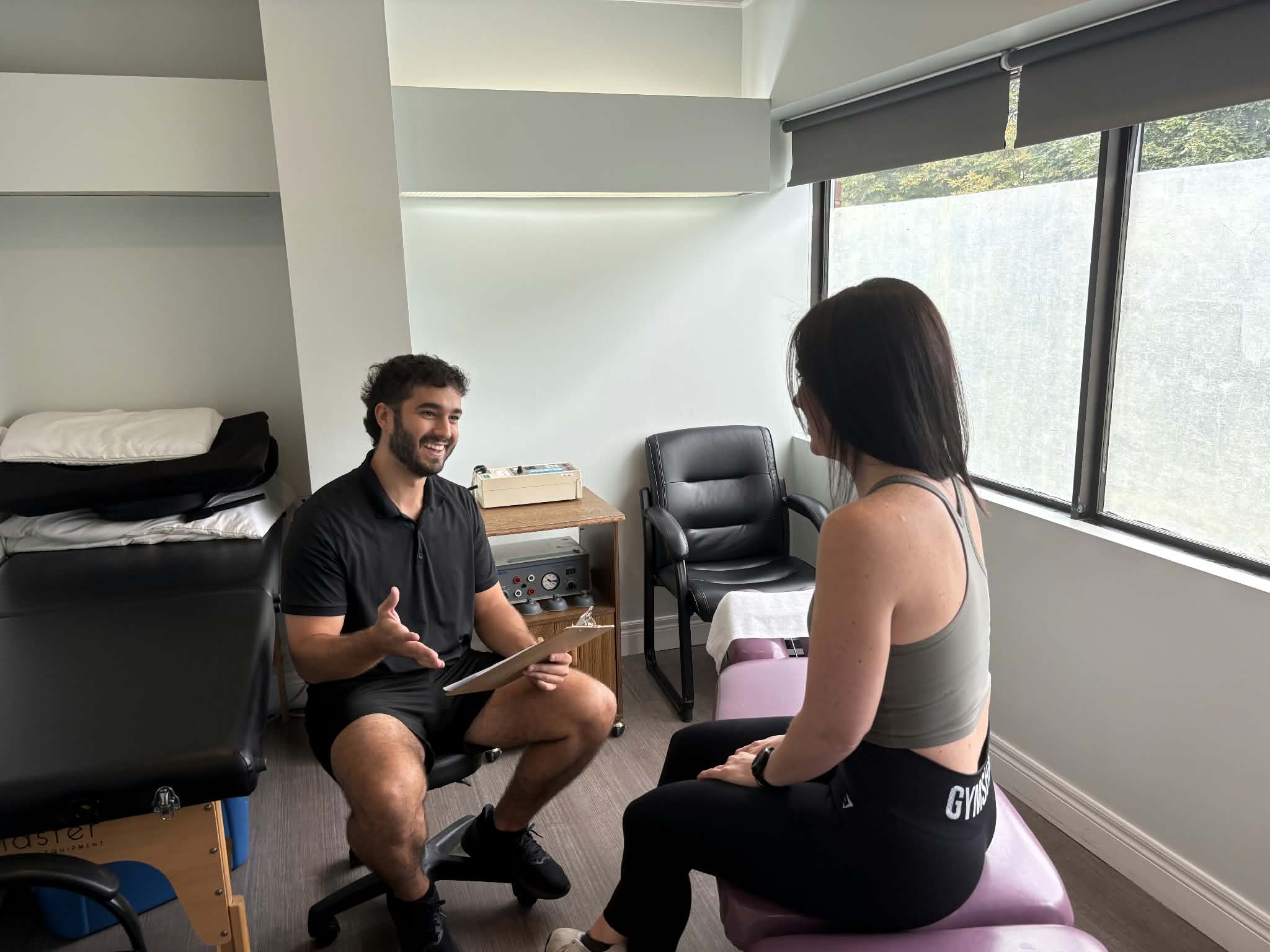 Dr. Alex doing an assessment on a female patient with tailbone pain