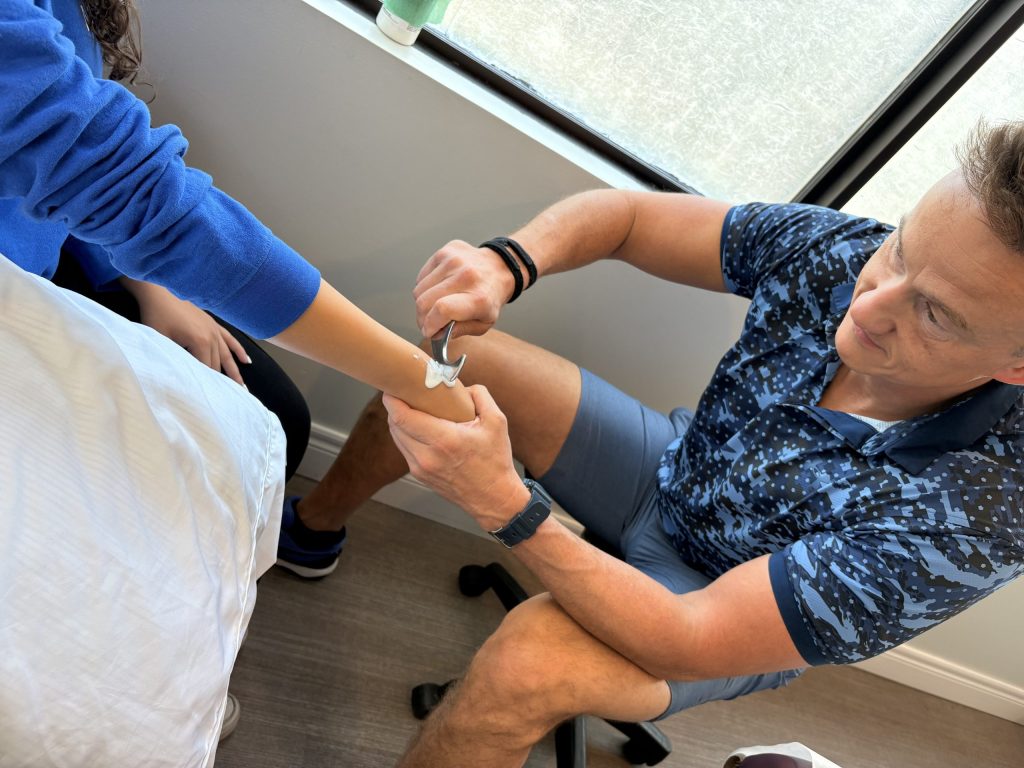Dr. Steve using his scraping tool on a patients right TFCC