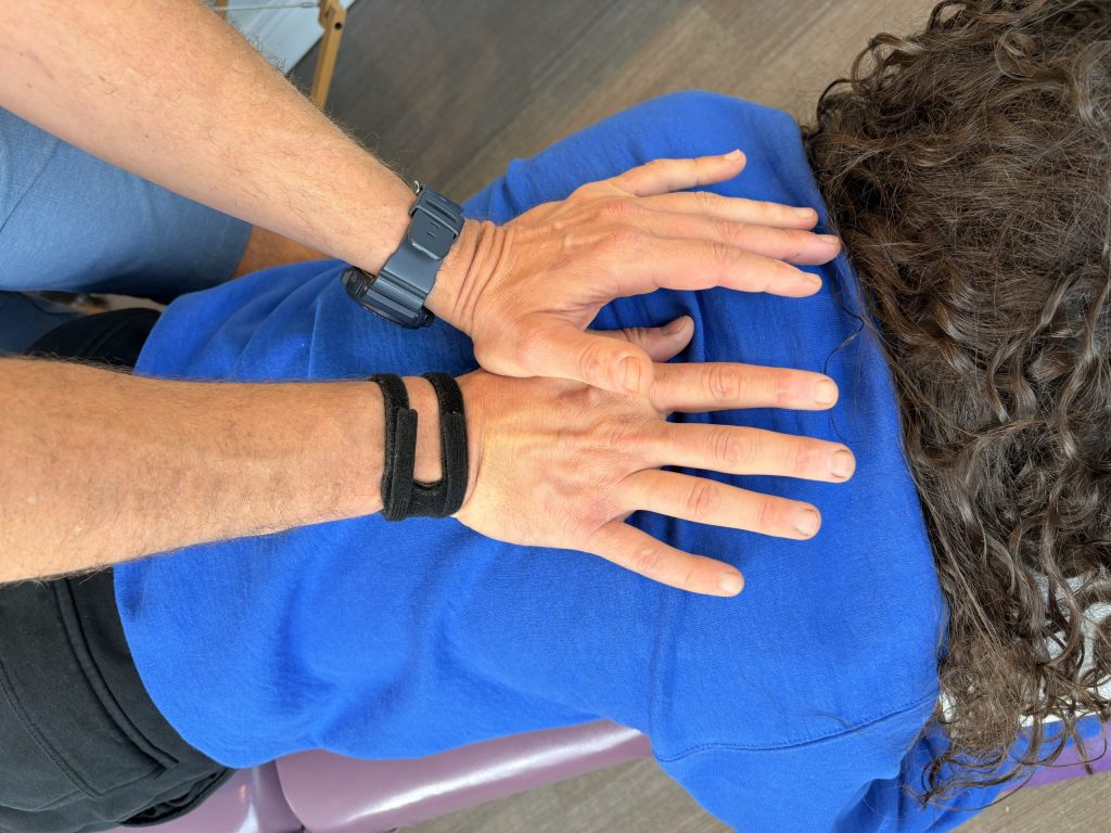 A physiotherapist treating a patient while wearing a TFCC brace