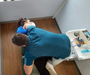 Thoracolumbar chiropractic adjustment by Dr. Steve. His top arm is in the patients armpit, while the patient is on their side.