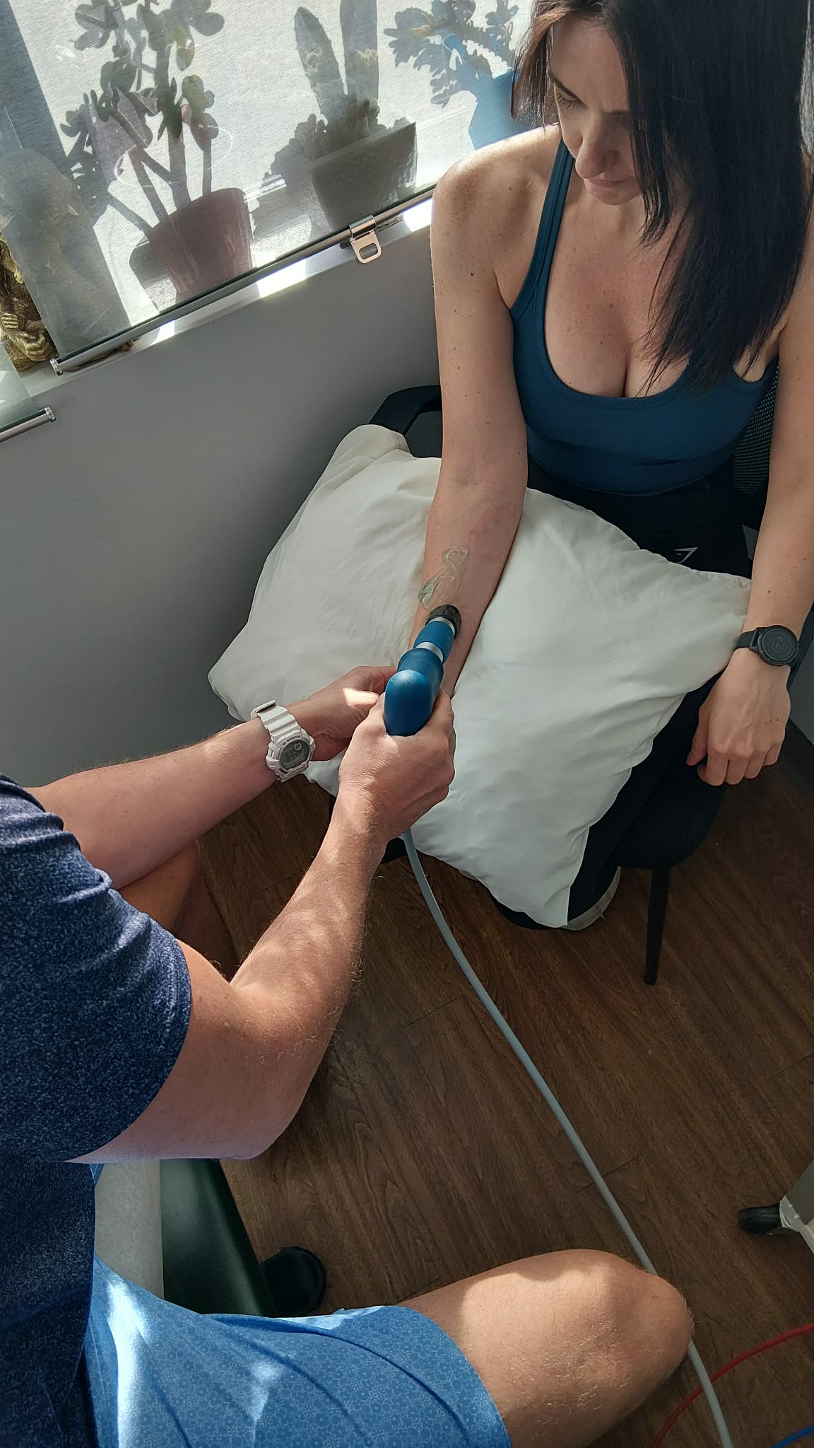 Dr. Steve performing shockwave therapy on a female patients arm